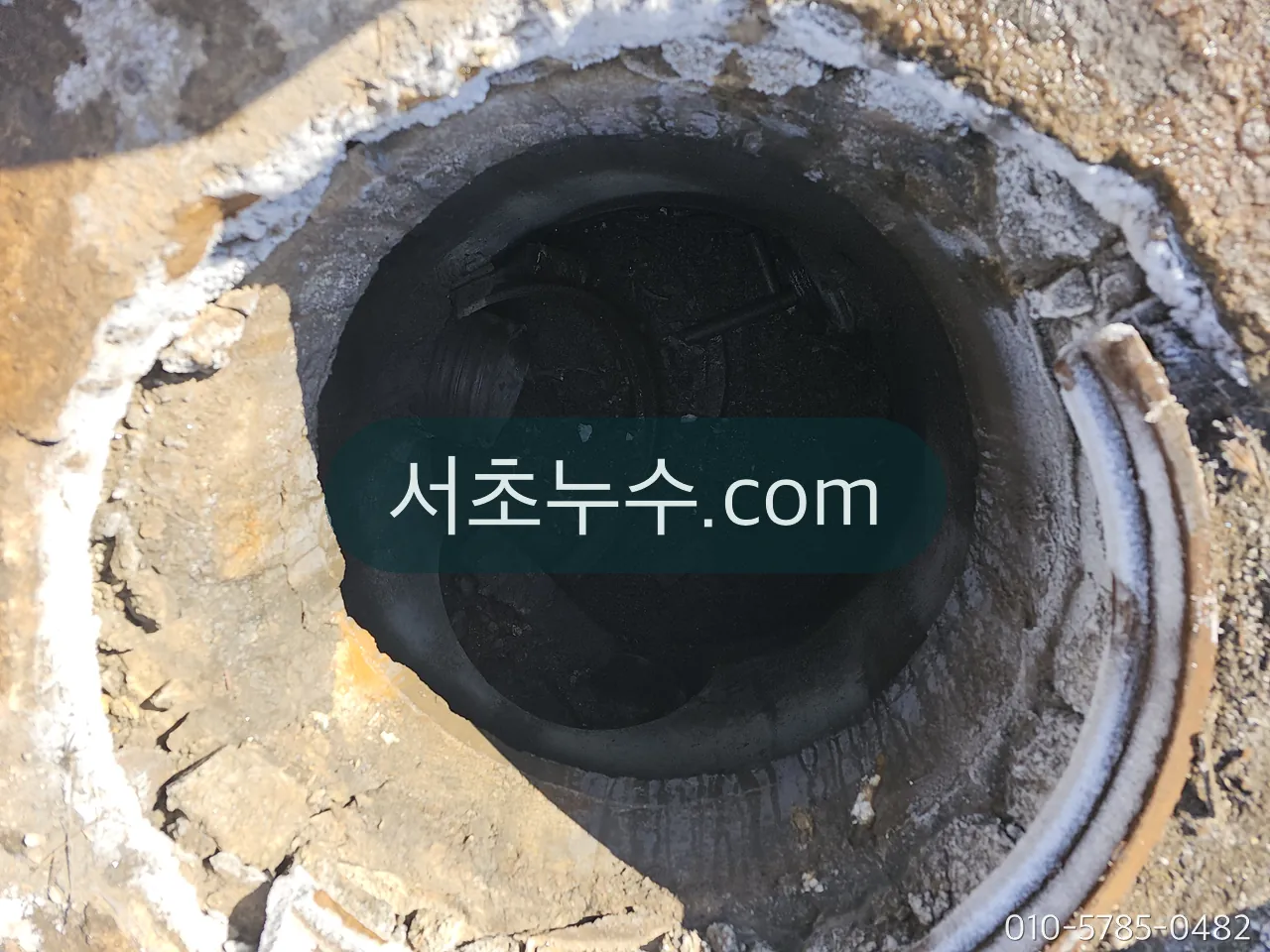 동절기 옥외 계량기함 내부 — 결빙이 풀린 뒤 배관과 이음부를 확인하는 장면