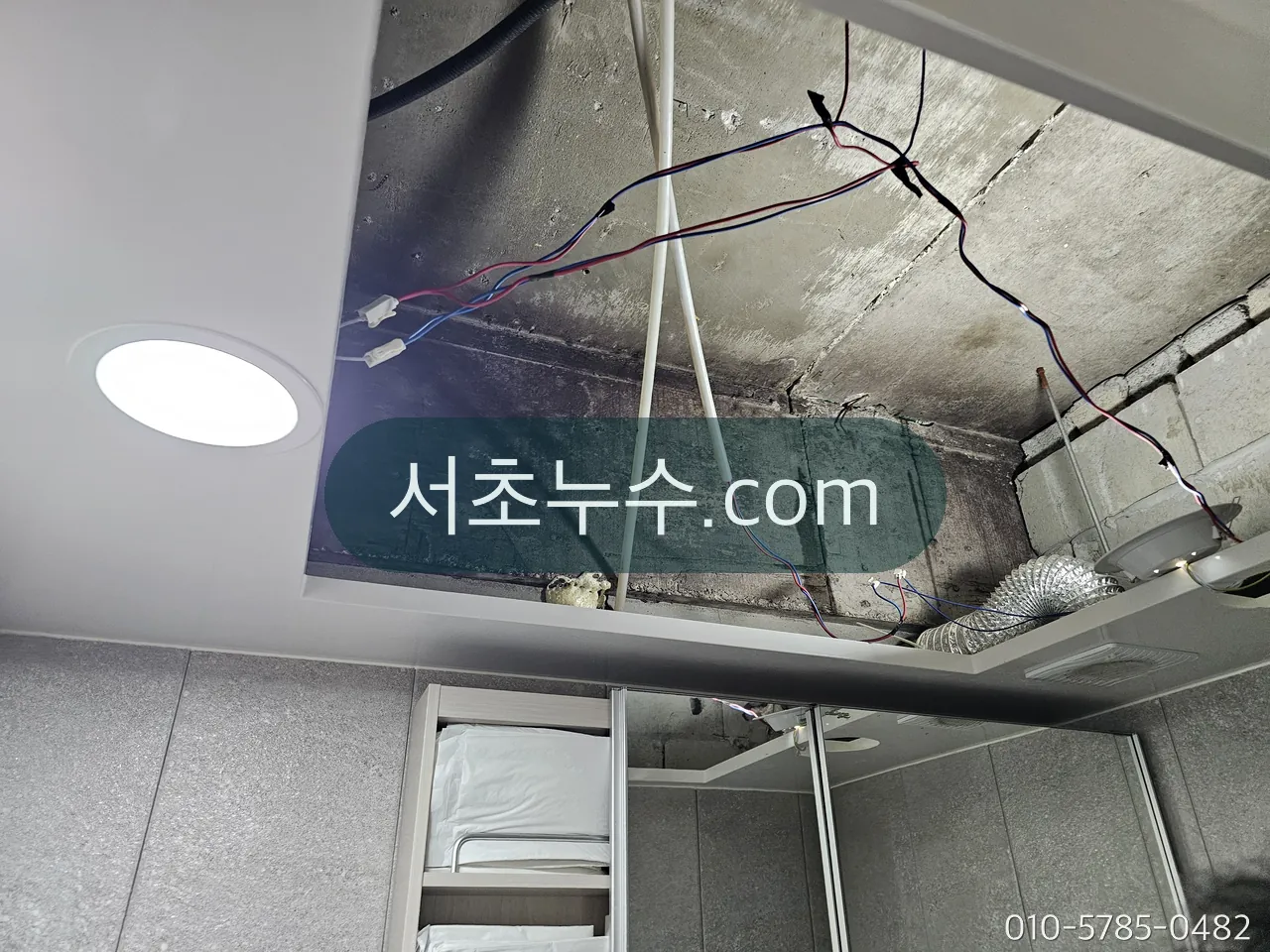 천장 점검구를 열어 위층 배관을 확인하는 모습