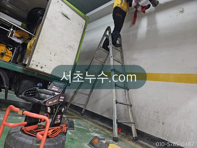 지하주차장 천장을 사다리로 점검하는 작업