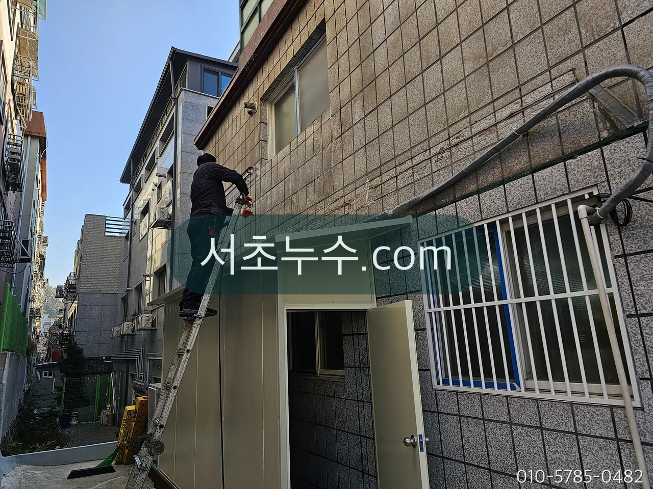 빌라 외벽을 따라 내려오는 홈통 라인을 점검하는 모습