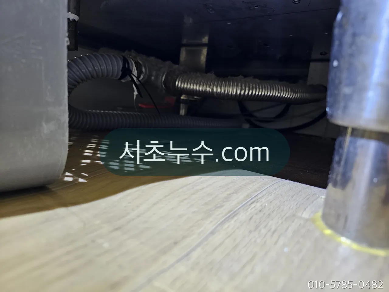 가구 아래로 지나는 드레인 주름호스 연결부