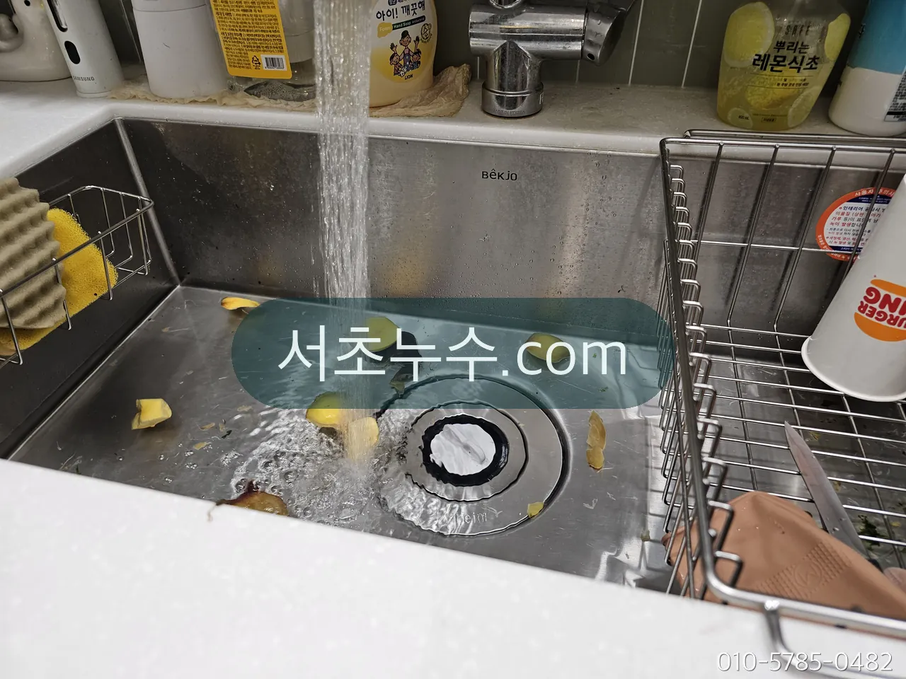 싱크대 수전 토수구와 배수구 주변을 확인하는 모습