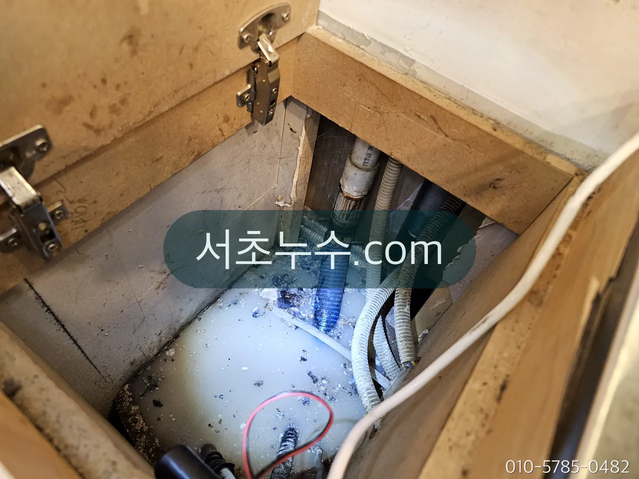 세면대 하부장 안 연결 호스·앵글밸브와 바닥에 고인 물